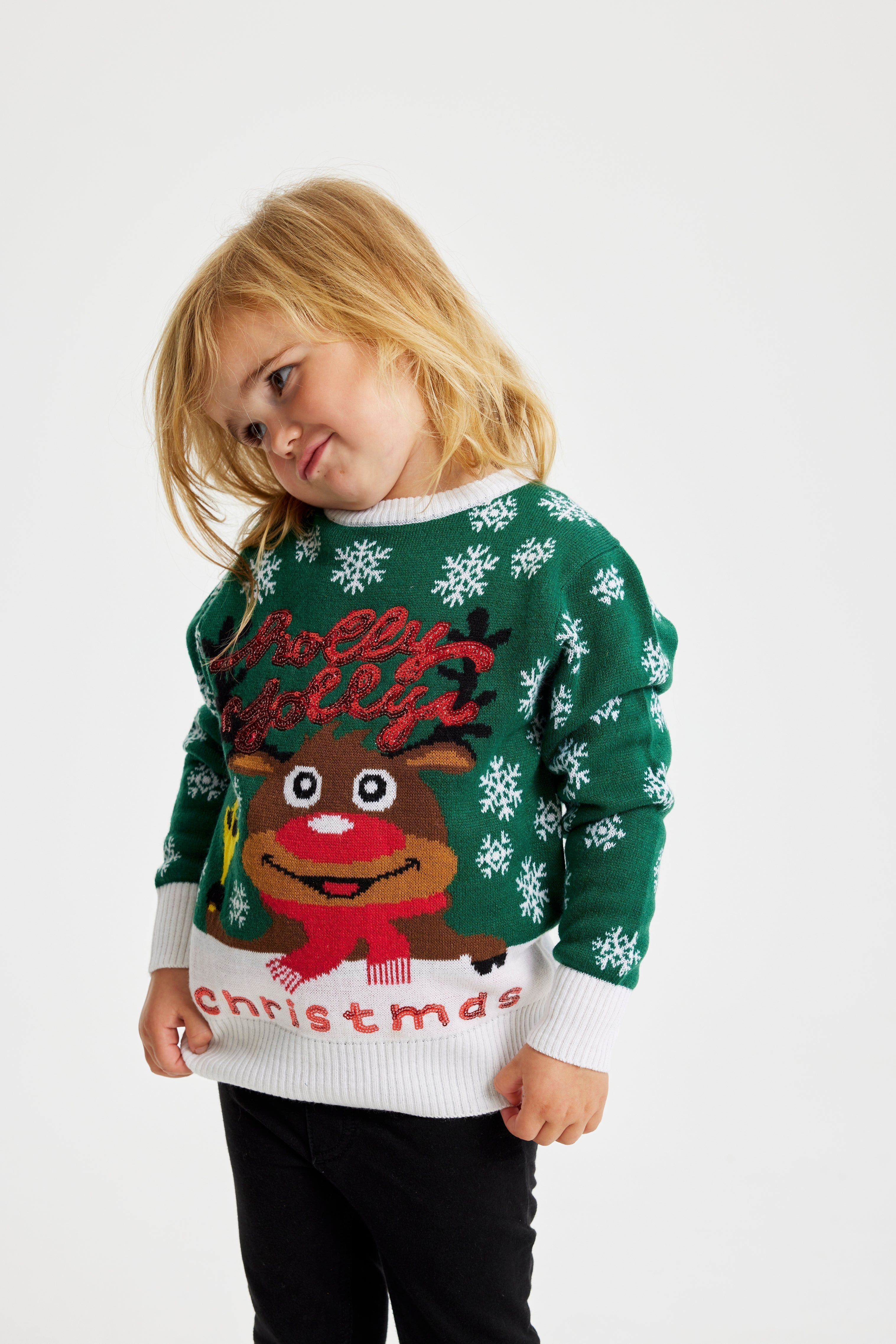 Un enfant portant un pull vert de Noël avec Rudolph.